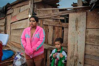 Sandra Micaela do Reis, 33 anos, com um dos filhos; ela conta que as poucas roupas de inverno são de doações (Foto: Marcos Maluf)