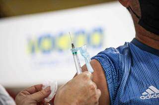 Homem recebendo dose de vacina contra covid-19 em Campo Grande. (Foto: Henrique Kawaminami)