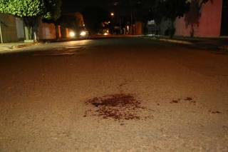 Sangue do homem baleado ficou no asfalto. (Foto: Kisie Ainoã)
