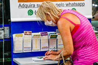 Apostadora marcando as dezenas da sorte em lotérica da Capital. (Foto: Henrique Kawaminami)