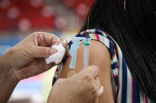 Profissional de saúde prepara curativo após aplicar vacina em mulher (Foto: Arquivo)