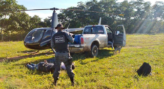 Dois presos próximo ao helicóptero interceptado por policiais militares nesta manhã (Foto: divulgação / Polícia Militar) 