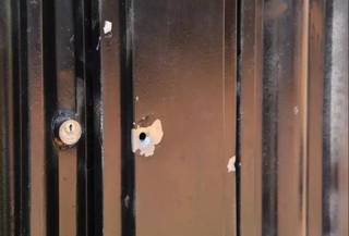 Marcas de tiros no portão da casa da vítima, no Jardim Itamaracá, em agosto do ano passado (Foto: Kisie Aionã)
