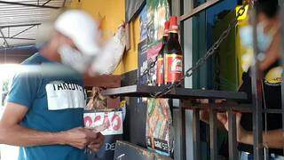Flagrante de cliente comprando garrafas geladas de cerveja em conviência no Nova Lima (Foto: Campo Grande News)