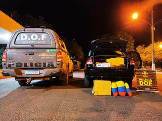 Viatura do DOF ao lado do veículo onde a droga estava sendo transportada. (Foto: DOF)