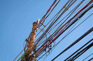 Emaranhado de fios de energia em poste de rua da Capital. (Foto: Henrique Kawaminami) 