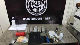 Pacotes de droga, dinheiro e outros objetos encontrados na casa de suspeito (Foto: Adilson Domingos)