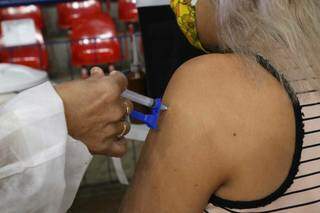 Mulher recebe dose do imunizante no ginásio Guanandizão (Foto: Kísie Ainoã)