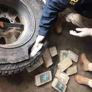 Parte da droga sendo retirada de pneu step da camionete. (Foto: Divulgação | PRF)
