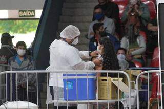 Mulher é vacinada contra a covid-19 em Campo Grande, uma das frentes para reduzir o impacto da doença. (Foto: Marcos Maluf)