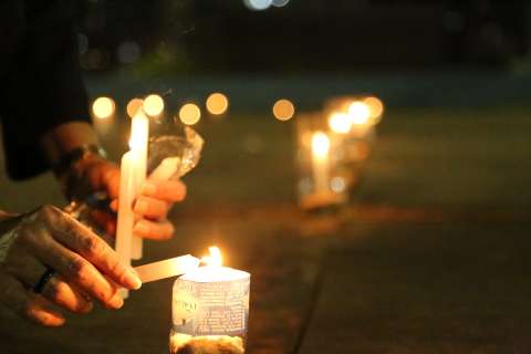Grupo acende velas em homenagem a meio milhão de mortos por covid-19