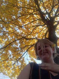 Lilian com árvore florida ao fundo. (Foto: Arquivo Pessoal)