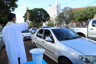 Padre Adriano concedendo a benção a um dos carros da fila (Foto: Kísie Ainoã)