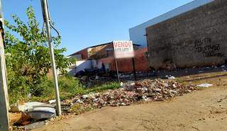 Terreno baldio entulhado de lixo e com pessoas morando em tenda (Foto: Direto das Ruas)