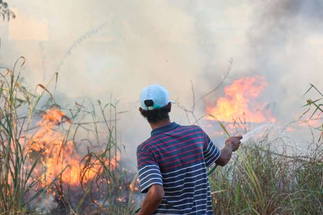 Em alerta com fogo, moradores tentam apagar chamas com mangueiras