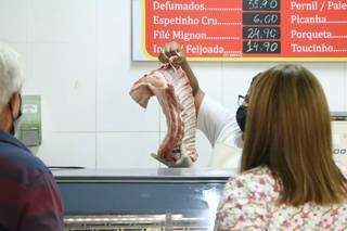 Consumidores observam peça de carne, um dos itens que mais encareceu, em açougue de Campo Grande (Foto: Kísie Ainoã/Arquivo)