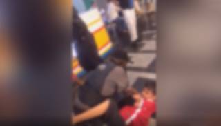 Adolescente no chão sendo contido por um dos seguranças (Foto: Reprodução)