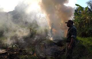 Homem observa fogo em terreno em Corumbá. (Foto: PMA)