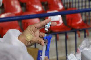 Imunizante contra a covid-19 sendo administrado por uma profissional da saúde em Campo Grande (Foto: Kísie Ainoã)