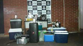 Garrafas de bebidas, aparelho de som e ilimunação, apreendidos na festa (Foto: Guarda Municipal da Dourados)