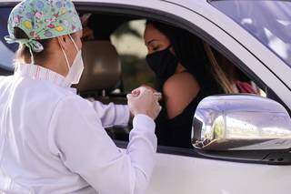 Moradora é vacinada em drive-thru montado em shopping de Pedro Juan (Foto: Divulgação)
