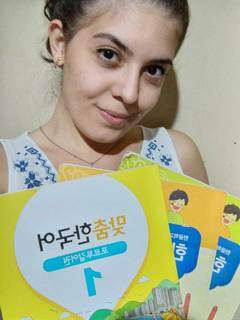Karolayne exibe os livros de coreano com quais estuda. (Foto: Arquivo Pessoal)