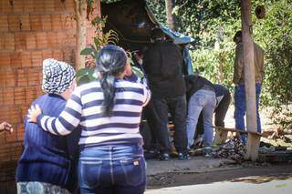 Família acompanha o trabalho da polícia na chácara onde corpo foi encontrado. (Foto: Henrique Kawaminami)