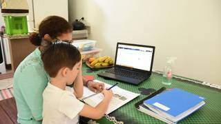 Menino acompanha aula online com a companhia da mãe (Foto: PMCG)