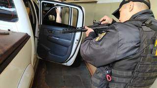 Policial do DOF observa mira de fuzil encontrado em caminhonete (Foto: Adilson Domingos)