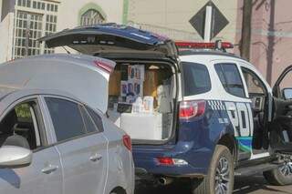 Porta-malas do carro e da viatura abertos, com o veículo da polícia já com o contrabando. (Foto: Marcos Maluf)