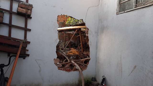 Vizinhos e PM quebram muro para socorrer mulher de casa pegando fogo