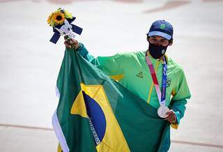 Kelvin segura a bandeira do Brasil e exibe a medalha de prata que conquistou na competição (Foto: Reprodução/CBS)