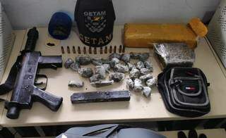 Submetralhadora, munições e pacotes de maconha encontrados na “boca” (Foto: Adilson Domingos)