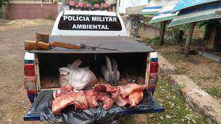 Rifle e 42 quilos de carne de porco do mato foram apreendidos com caçadores (Foto: Divulgação/PM)