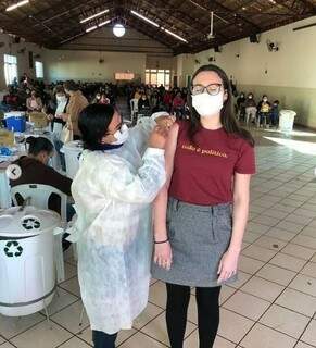 Laura recebendo dose da vacina em Campo Grande, emocionada. (Foto: Arquivo Pessoal)