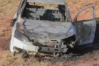 Carro ficou destruído pelas chamas, fogo começou depois que bandidos perderam controle da direção. (Foto: Marcos Maluf)