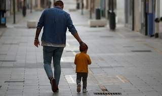 Lado a lado, pai e filhos caminham pela calçada. (Foto: Reprodução/Jon Nazca/Reuters)