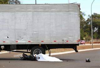 Motocicleta ficou embaixo do caminhão e capacete longe do corpo. (Foto: Paulo Francis)
