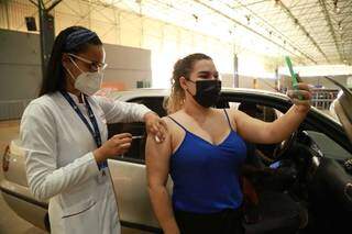Caroline Polesel, de 24 anos, no momento da vacinação contra covid-19. (Foto: Kísie Ainoã)
