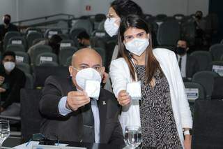 Na foto, o vereador Ronilço Guerreiro ao lado de Camila Jara, segurando os absorventes distribuídos por ela antes da votação. (Foto: Divulgação/CMCG)