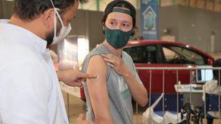 Jovem recebe dose da vacina contra covid em drive-thru. (Foto: PMCG)