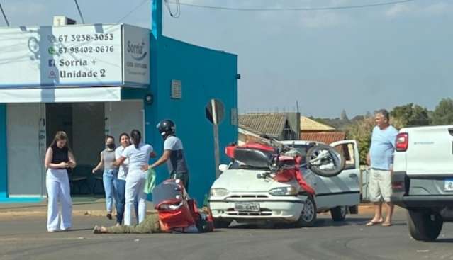Motocicleta para em cima de Palio durante acidente em cruzamento