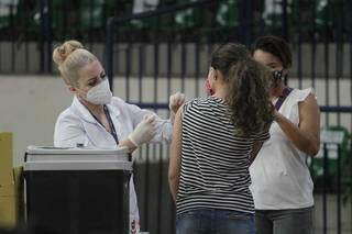 Adolescente sendo vacinada na manhã deste domingo na Capital. (Foto: Marcos Maluf)