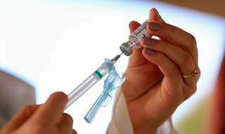 Profissional aspira dose em ampola de vacina (Foto: Myke Sena/MS)