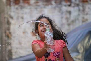 Ana Julia, de 9 anos, brinca com garrafa d&#39;água para se refrescar. (Foto: Marcos Maluf)