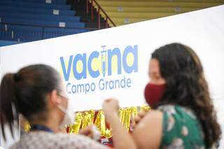 Jovem é imunizada no posto montado no Guanandizão (Foto: Henrique Kawaminami)