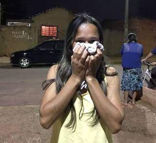 Mulher cobre o rosto no meio da rua, depois do gás tomar conta do bairro.