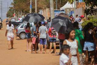 Pessoas usaram guardas-chuva para se proteger do sol na fila. (Foto: Marcos Maluf)