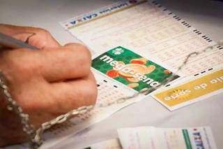 Apostador marcando as dezenas da sorte na lotérica. (Foto: Henrique Kawaminami)