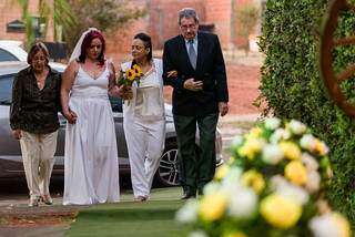 Kamila e Paula entrando com os pais na cerimônia de casamento. (Foto: Celso Magalhães)